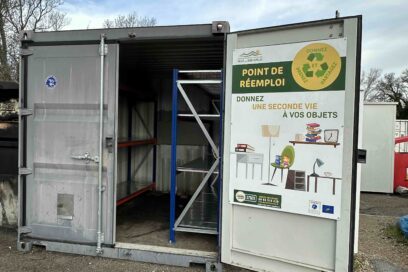 Container blanc accueillant deux étagères en métal et un panneau "Point de réemploi" sur la porte ouverte - Agrandir l'image, fenêtre modale