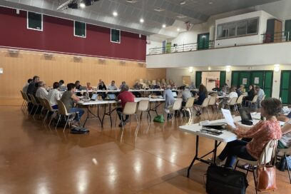 Les élus communautaires sont tous assis autour de tables en cercles dans la grande salle des fêtes d'Eygalières - Agrandir l'image, fenêtre modale